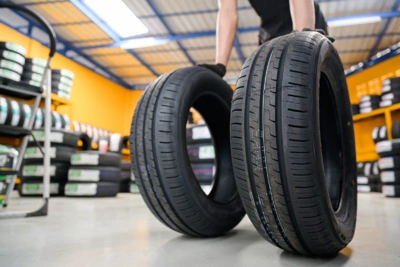 Two tires being pushed by a car service technician
